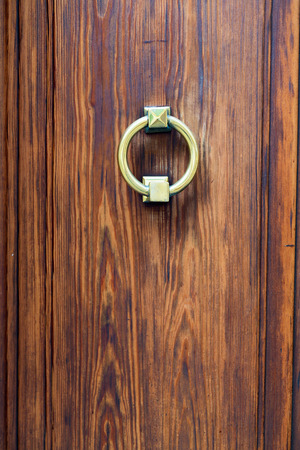 Antique brass door handle on a wooden door close-up