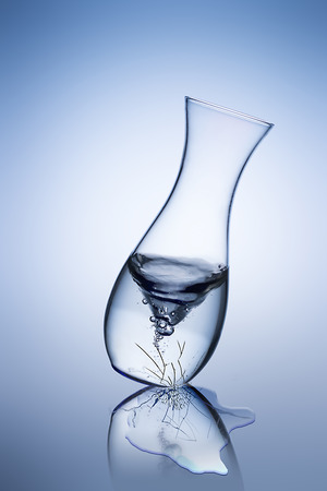 broken cracked glass vase with water flowsの写真素材