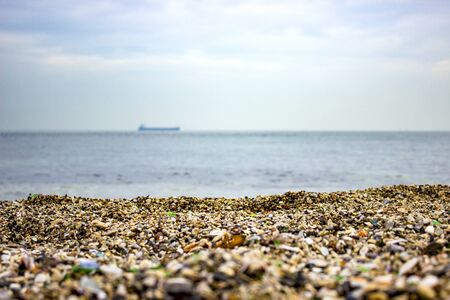 blue sea sandy shore and ship on the horizonの写真素材