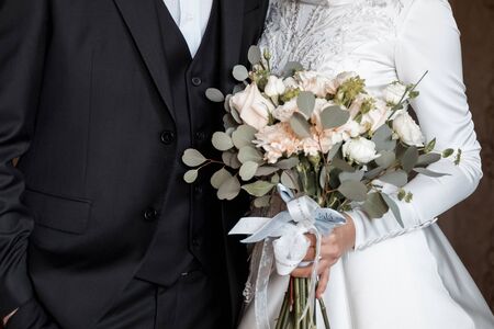 bride and groom with a bouquet in handの写真素材