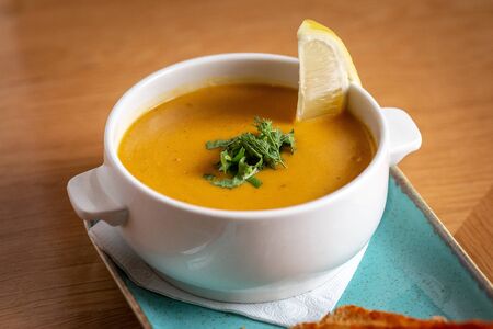 lentil soup with crackers and lemon on a wooden table