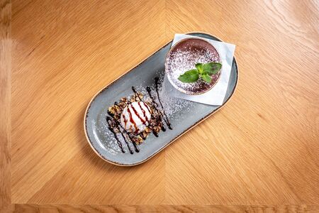 chocolate fondue with a piece of mint on the tableの写真素材