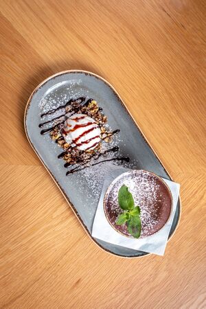 chocolate fondue with a piece of mint on the tableの写真素材