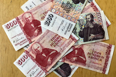Icelandic cash. Money of Iceland. Several Icelandic krona bills on wooden table. Icelandic krona is the national currency of Iceland (kronur)の写真素材