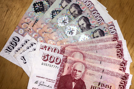 Icelandic cash. Money of Iceland. Several Icelandic krona bills on wooden table. Icelandic krona is...