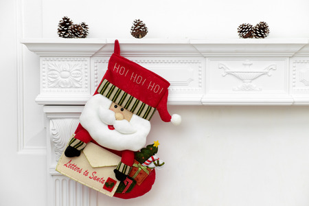 A close picture of beautifully decorated Santa Christmas socks with ho! ho! ho! word hanging on a...