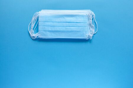 Prevent coronavirus. Medical protective masks isolated on blue background. Disposable surgical face...