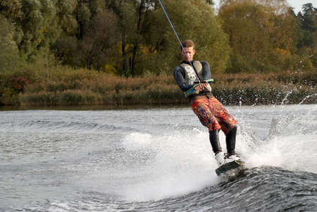Moscow, Russia - September 28, 2008: Wakeboarding rider showing tricks and skills at free ride on the city river. Wakeboarder behind the motorboatのeditorial素材