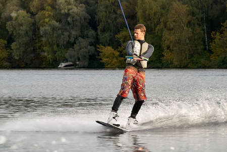 Moscow, Russia - September 28, 2008: Wakeboarding rider showing tricks and skills at free ride on the city river. Wakeboarder behind the motorboatのeditorial素材