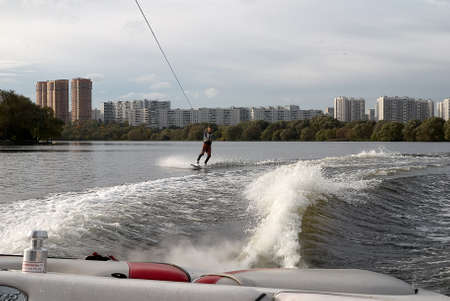 Moscow, Russia - September 28, 2008: Wakeboarding rider showing tricks and skills at free ride on the city river. Wakeboarder behind the motorboatのeditorial素材