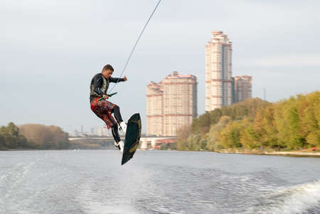 Moscow, Russia - September 28, 2008: Wakeboarding rider showing tricks and skills at free ride on the city river. Wakeboarder behind the motorboatのeditorial素材