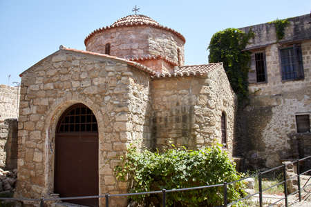 Small typical greek Chapel. Small building of Christian church on sunny day in ancient coastal townの写真素材