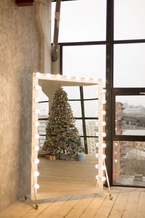 Reflection of the Christmas tree in the mirror, a large mirror near a large windowの写真素材