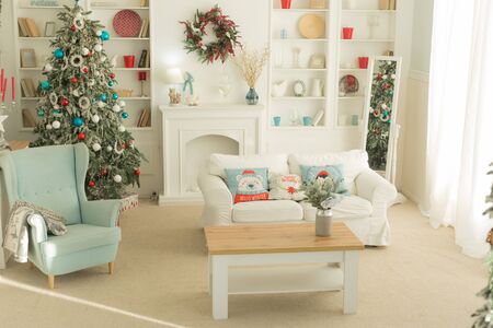 The interior of the Christmas room, a white sofa with pillows at the coffee table and a blue chairの写真素材