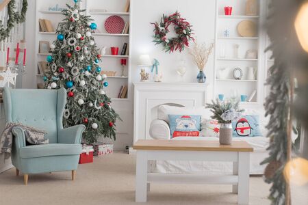 The interior of the Christmas room, a white sofa with pillows at the coffee table and a blue chairの写真素材
