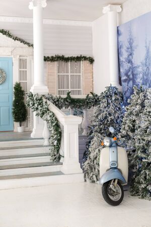 Retro scooter near the stairs of the house in the winter yardの写真素材