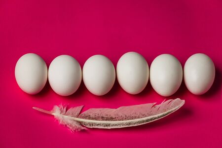 Close-up of white eggs on a simple pink background with a copy of space abstraction of food for...