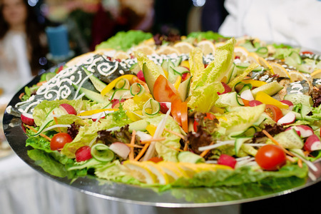 Dish of fish with vegetables on a tray in a restaurantの写真素材