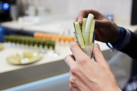 Close-up photo of thin cucumbers in a glass with salt in handの写真素材