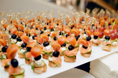 Amazing photo of  sandwiches with olives, tomato, cucumbers and fish in a white plateの写真素材