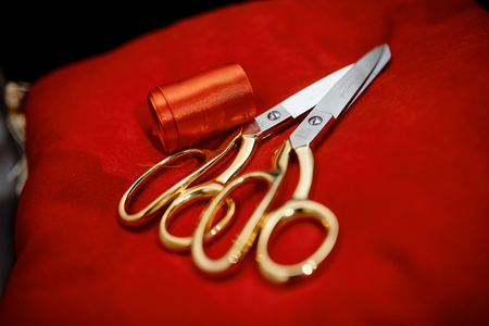 Amazing photo  of silver scissors with golden handle near silk ribbon on the silk clothの写真素材