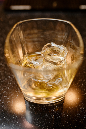 whiskey glass on a wooden table in a barの写真素材