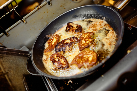 stewing white fish in a frying pan in a restaurant by a cookの写真素材