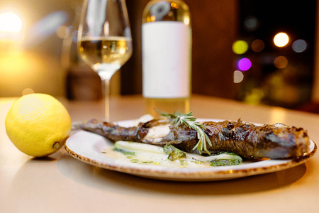 cleaned white fish with lemon ready to stew next to the panの写真素材