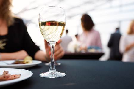 a glass of white and plates of food standing on a tray during the buffet tableの写真素材