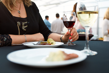 glasses of white and red wine and plates of food standing on a tray during the buffet tableの写真素材