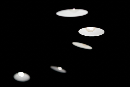 Five white lamps on the ceiling in the dark