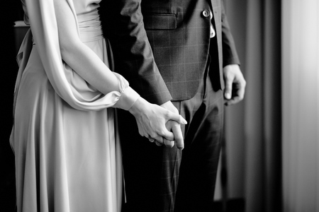 female hand holds male hand in black and white at the roomの写真素材