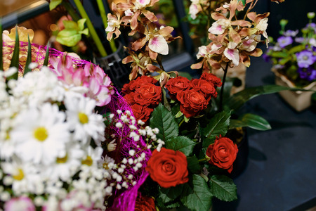 bouquets of flowers from roses, daisies, orchids on the tableの写真素材