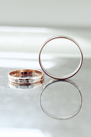 gold wedding rings are on the tableの写真素材
