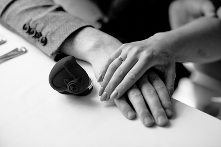 female hand on male hand on a table in a restaurantの写真素材