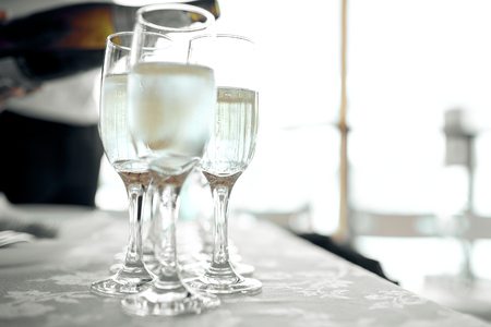 glasses of champagne are on a white tablecloth on the table at the weddingの写真素材