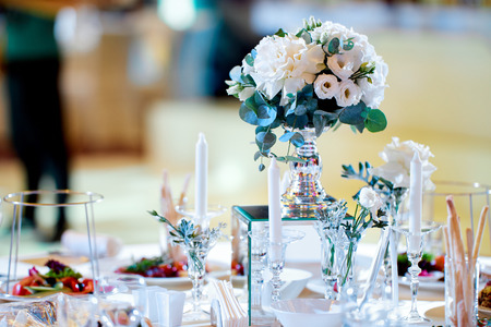 bridal bouquet of roses with greens on the table with candlesの写真素材