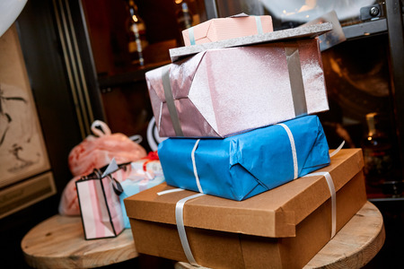 wrapped gifts of different sizes in different colors on the table in the restaurantの写真素材
