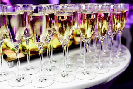 Crystal, clean wine glasses with chilled expensive champagne stand on a table for a welcome treat for the guests of the event.の写真素材