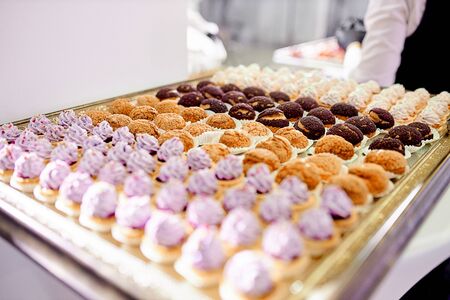 Caitring, delicious new welcome dessert snacks that stand on a table in a glass bowl and chocolate dessert in the backgroundの写真素材
