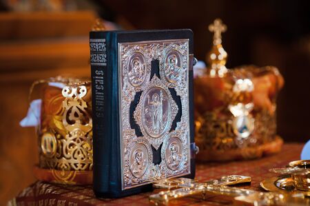 priest bible on the background of gold crowns and other church itemsの写真素材