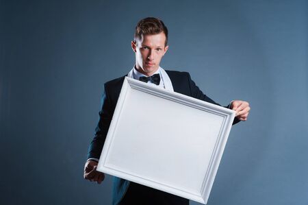 Smiling young casual man holding white sign to write it on your text isolated on white backgroundの写真素材