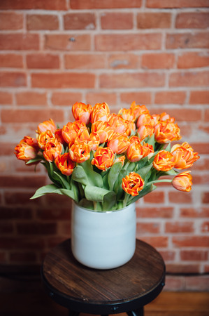 bouquet of orange tulips on the brick wall backgroundの写真素材