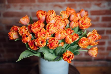 bouquet of orange tulips on the brick wall backgroundの写真素材