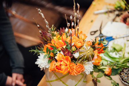 florist makes a basket with different flowers.の写真素材