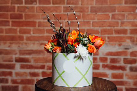 basket of spring flowers on a wooden chair. handmade.の写真素材