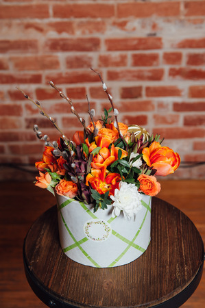 basket of spring flowers on a wooden chair. handmade.の写真素材