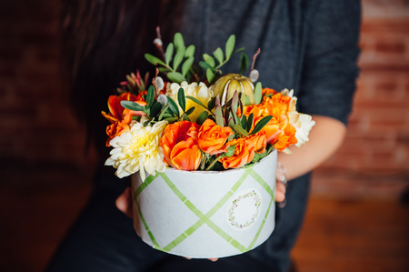 basket of spring flowers on a wooden chair. handmade.の写真素材