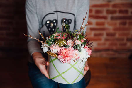 basket of spring flowers on a wooden chair. handmade.の写真素材