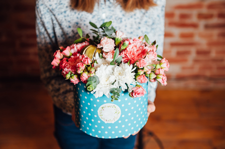 basket of spring flowers on a wooden chair. handmade.の写真素材